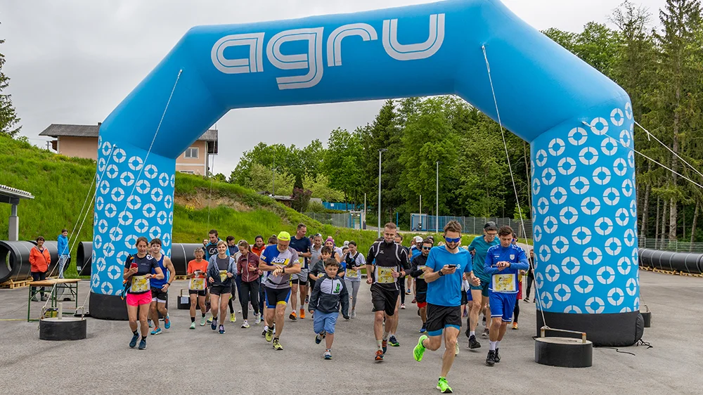 Trkači startuju ispod plavog AGRU nadvišnog luka na Wings for Life World Run 2025